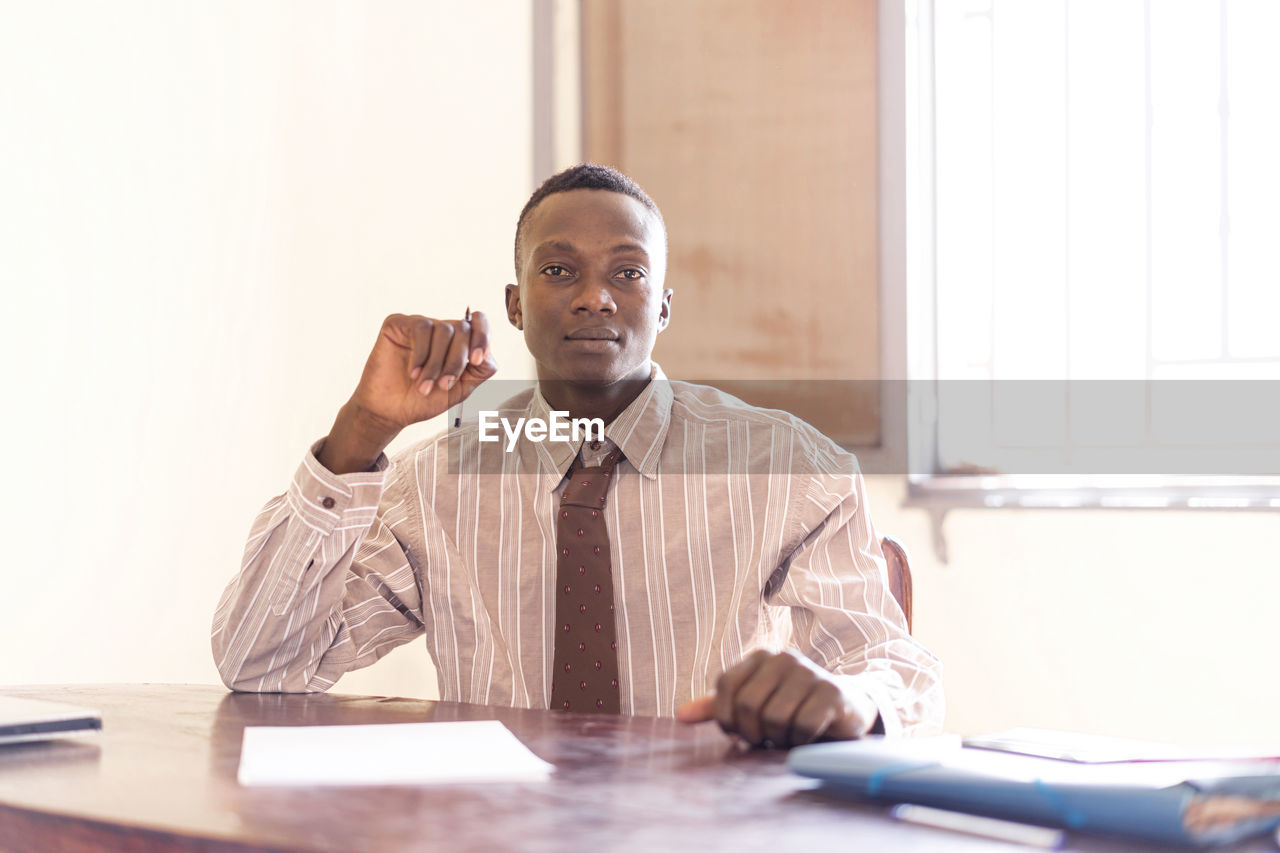 MID ADULT MAN USING SMART PHONE IN THE ROOM