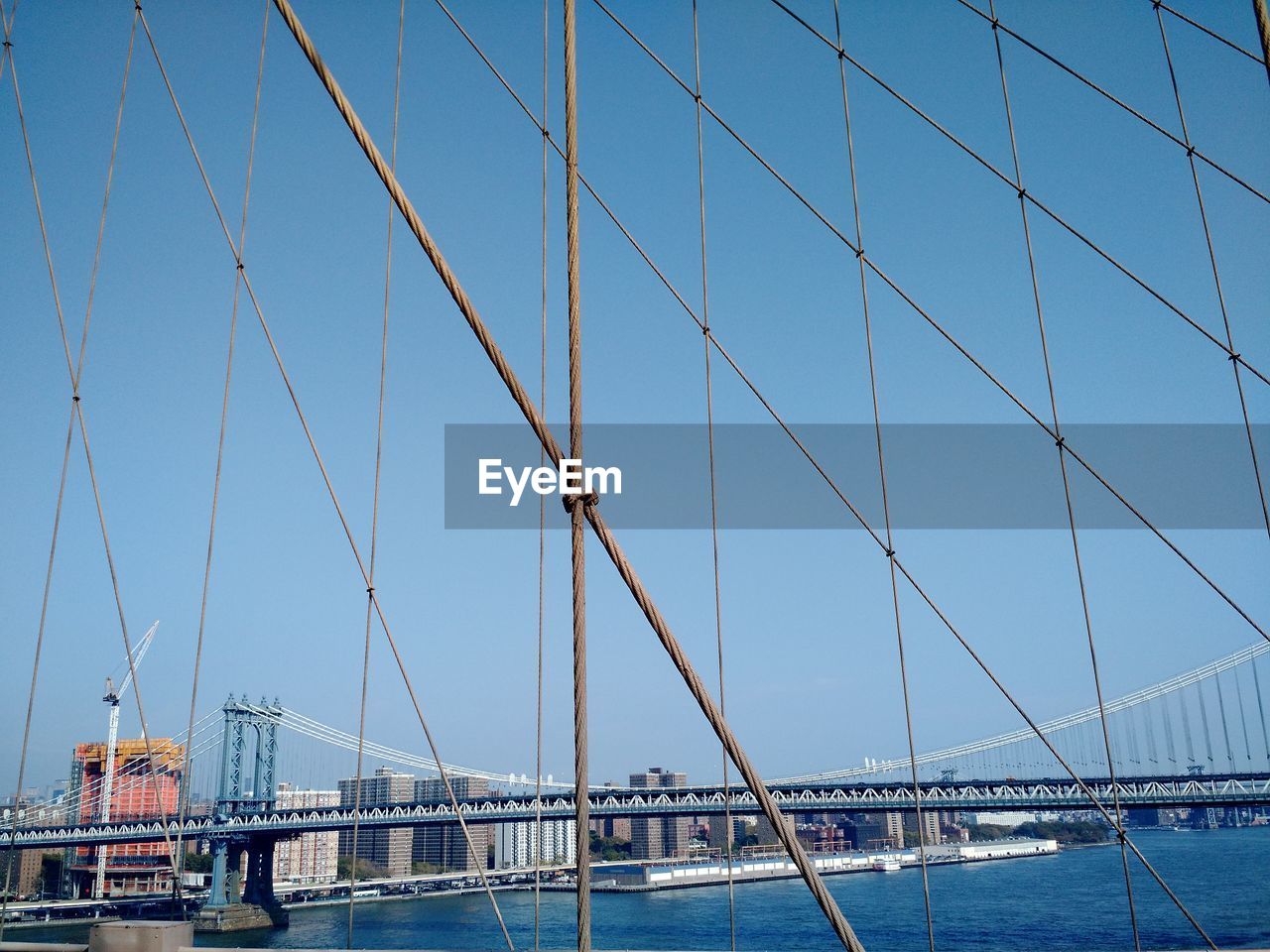 Suspension bridge over sea against sky