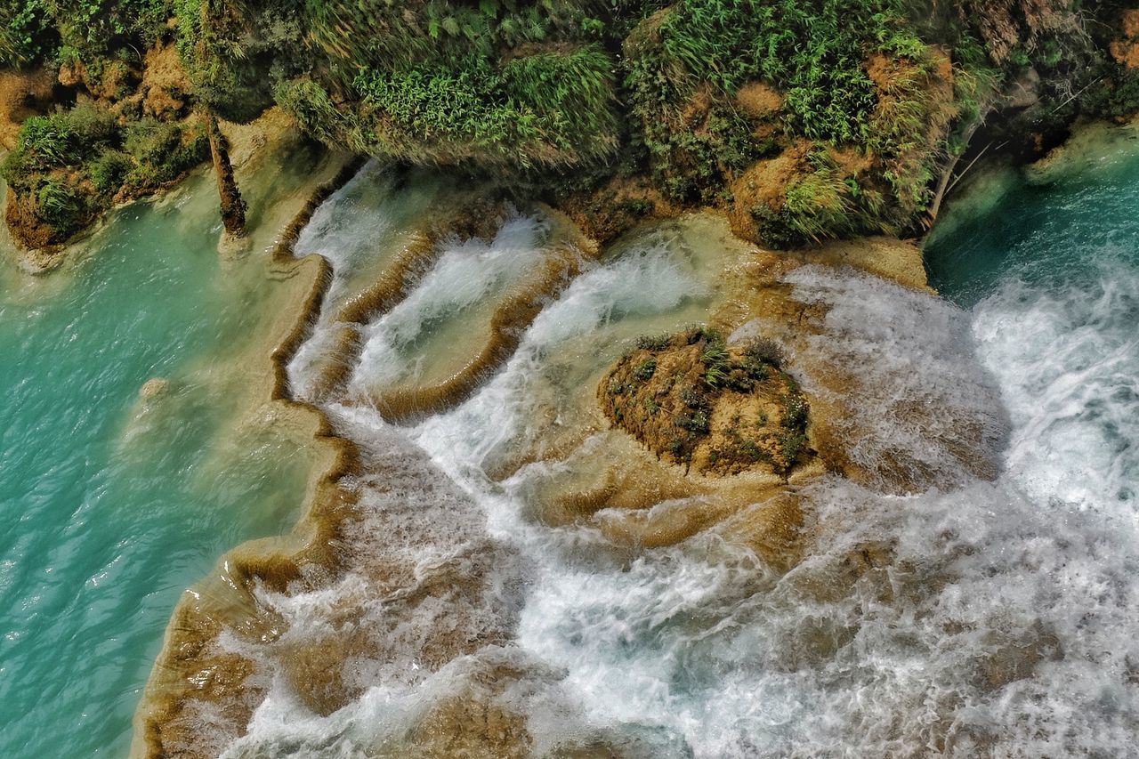 HIGH ANGLE VIEW OF WATER FLOWING FROM ROCKS