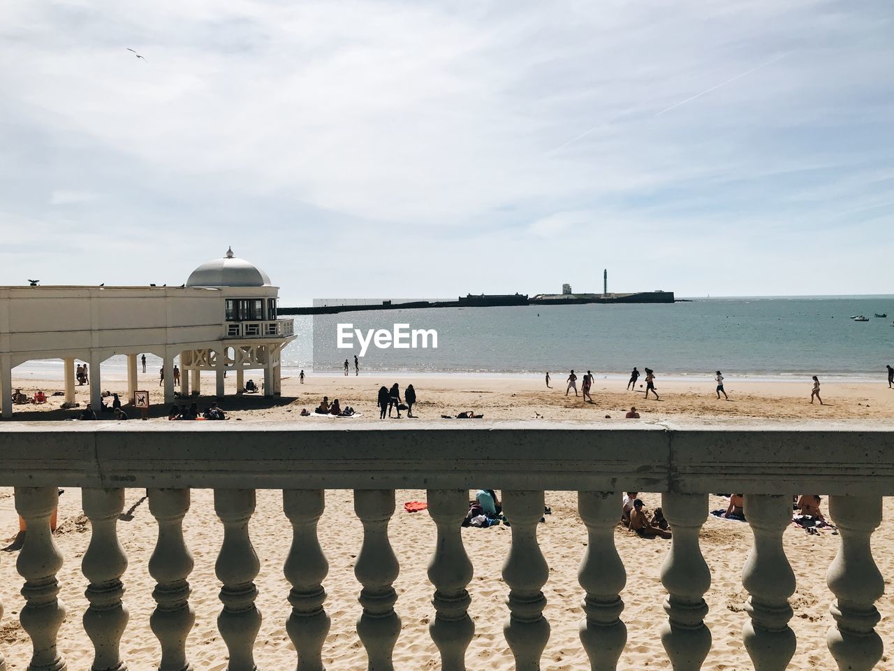 GROUP OF PEOPLE ON BEACH AGAINST SKY