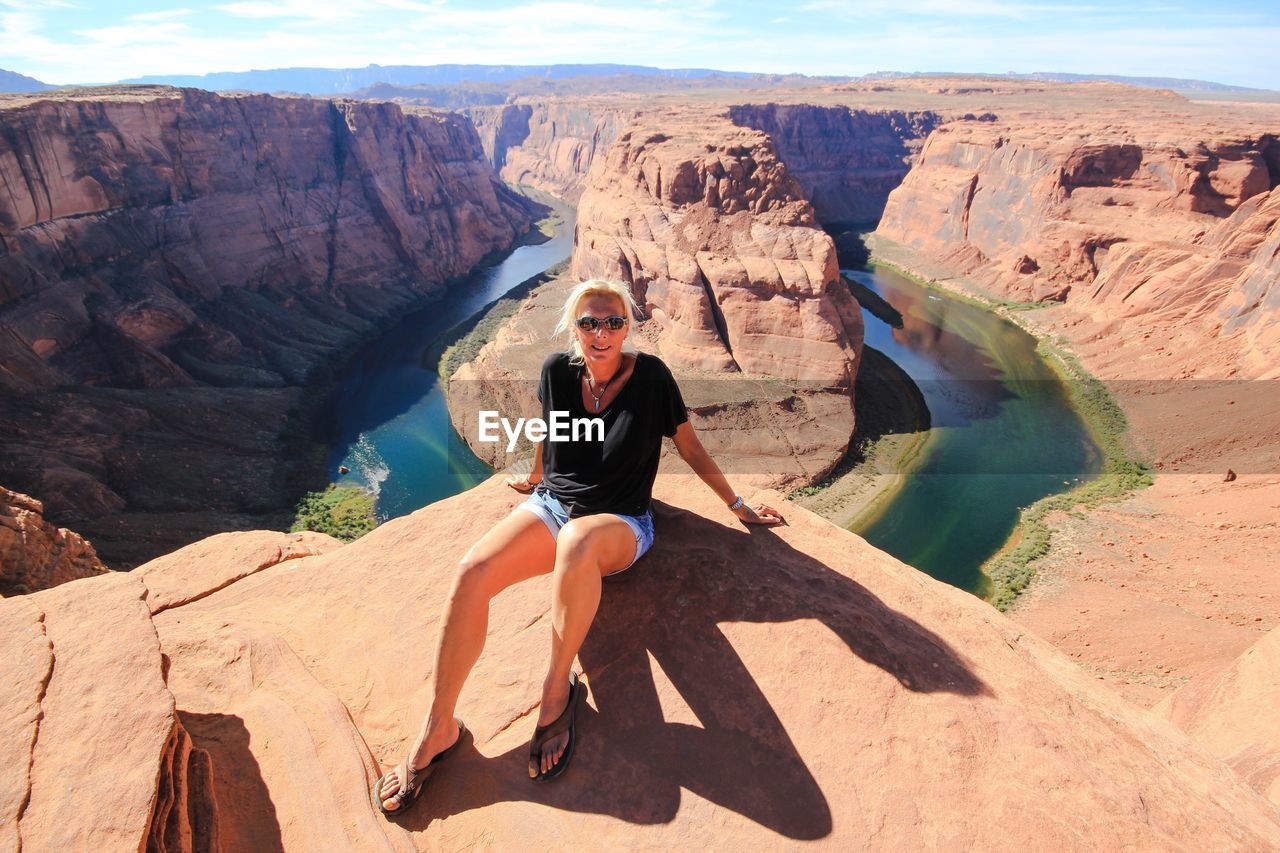 Portrait of woman sitting on mountain at horseshoe bend