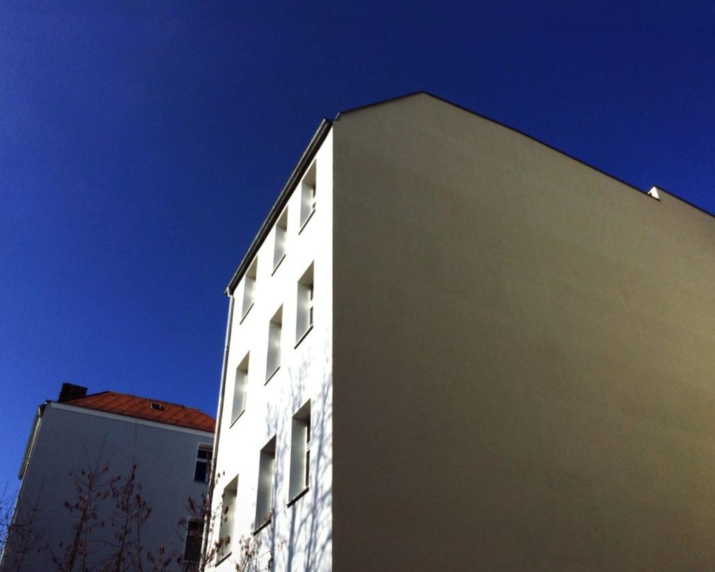 Low angle view of buildings against clear blue sky