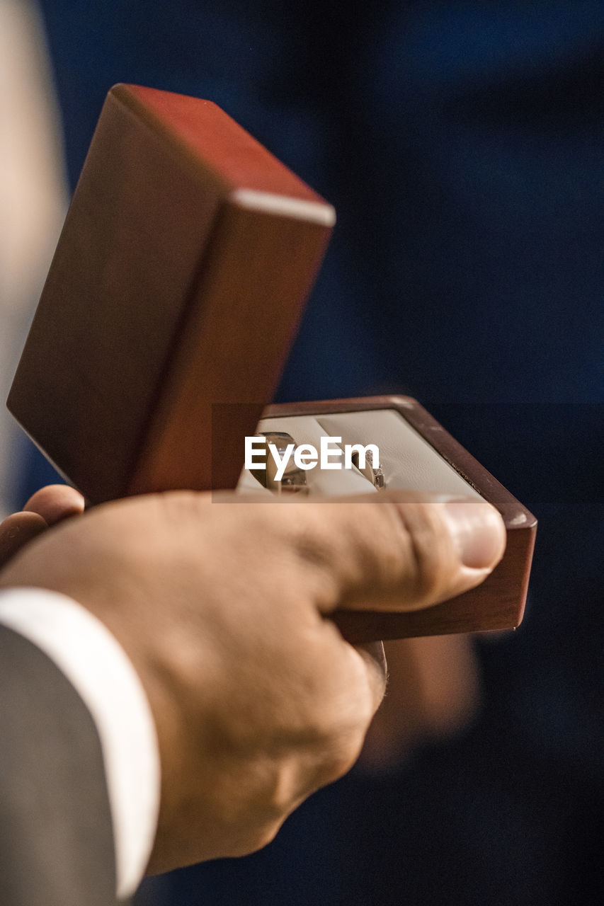 Close-up of man holding ring box