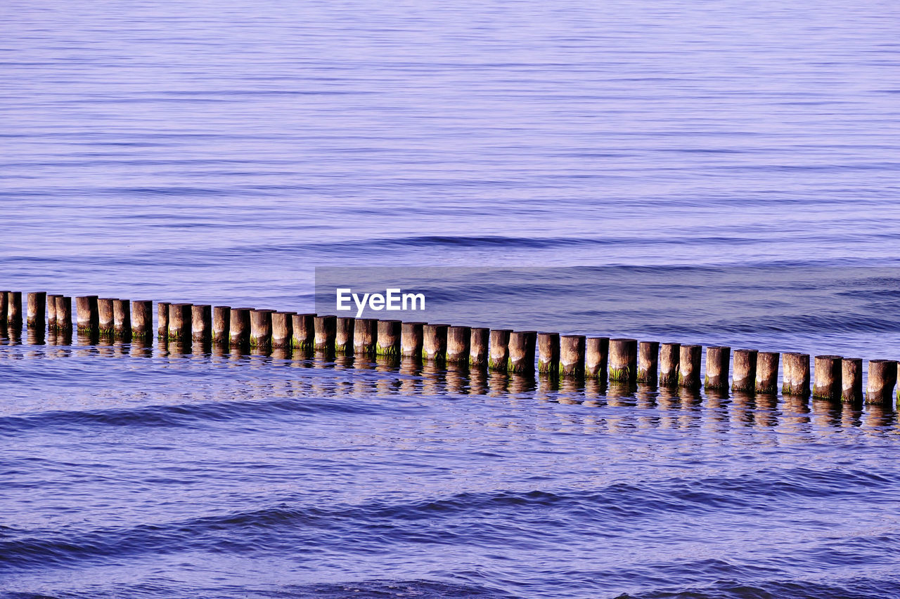 Wooden posts in sea