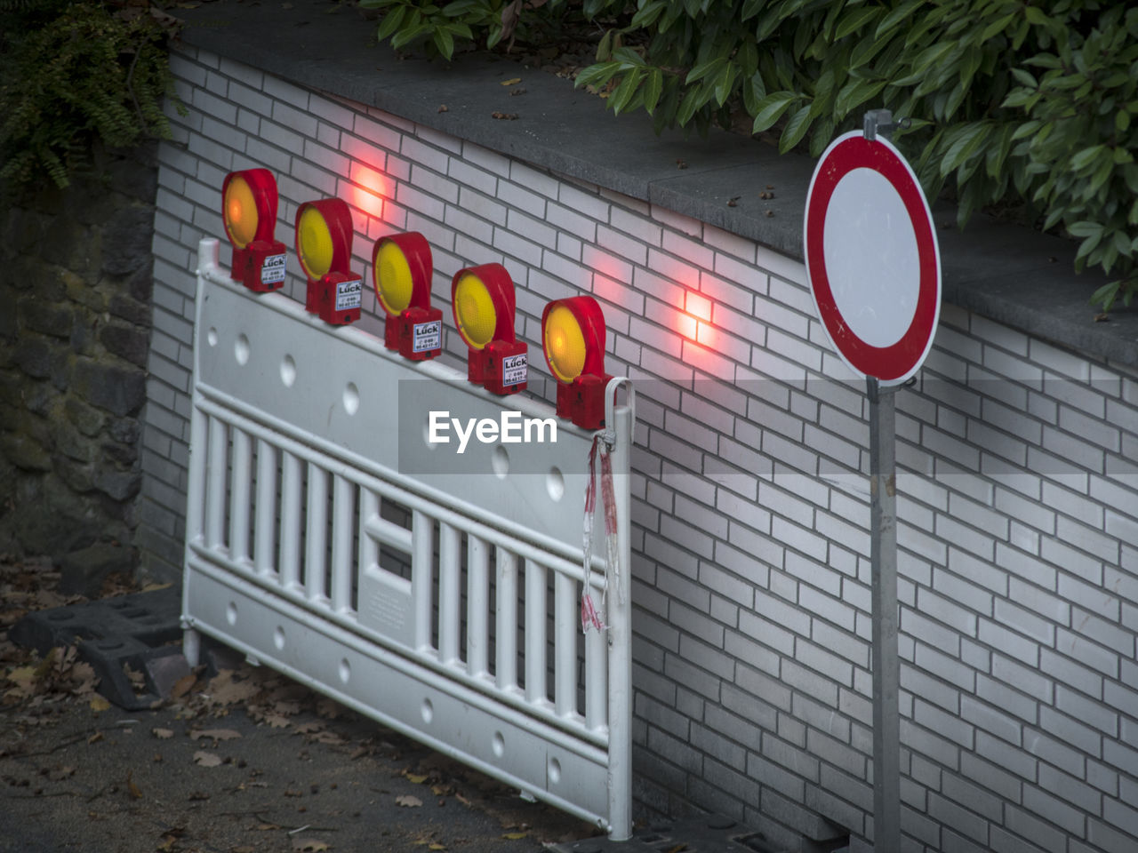 INFORMATION SIGN ON WALL BY ILLUMINATED ROAD