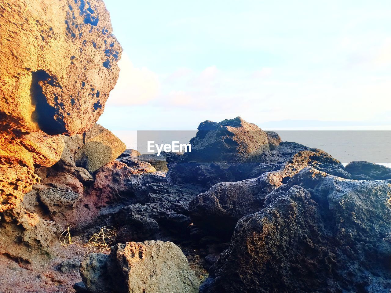 Rock formations on shore against sky