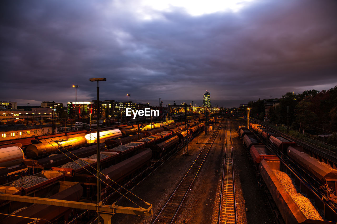 HIGH ANGLE VIEW OF TRAIN AT RAILROAD STATION AGAINST SKY