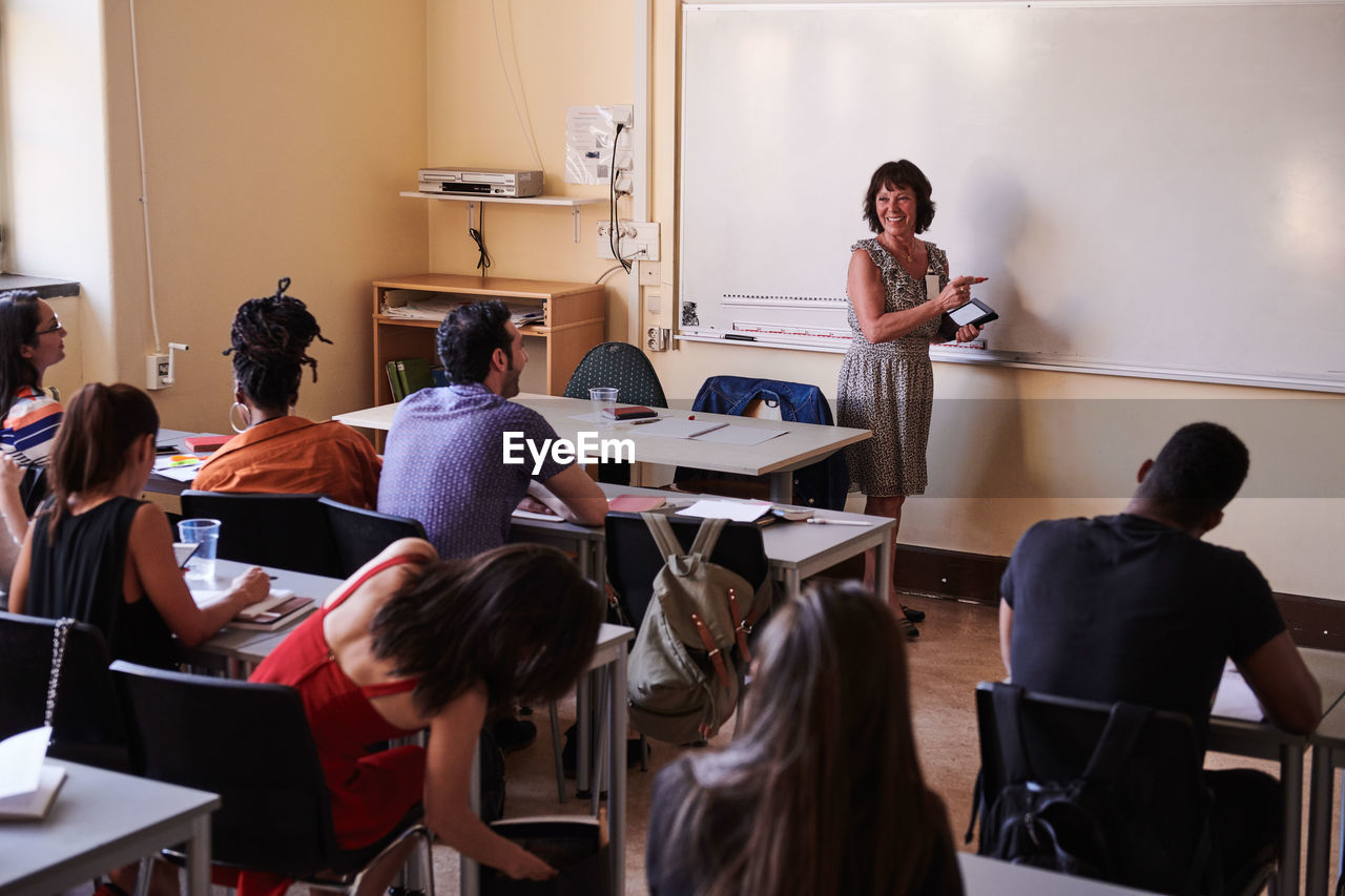 Female teacher smiling while teaching students in language class