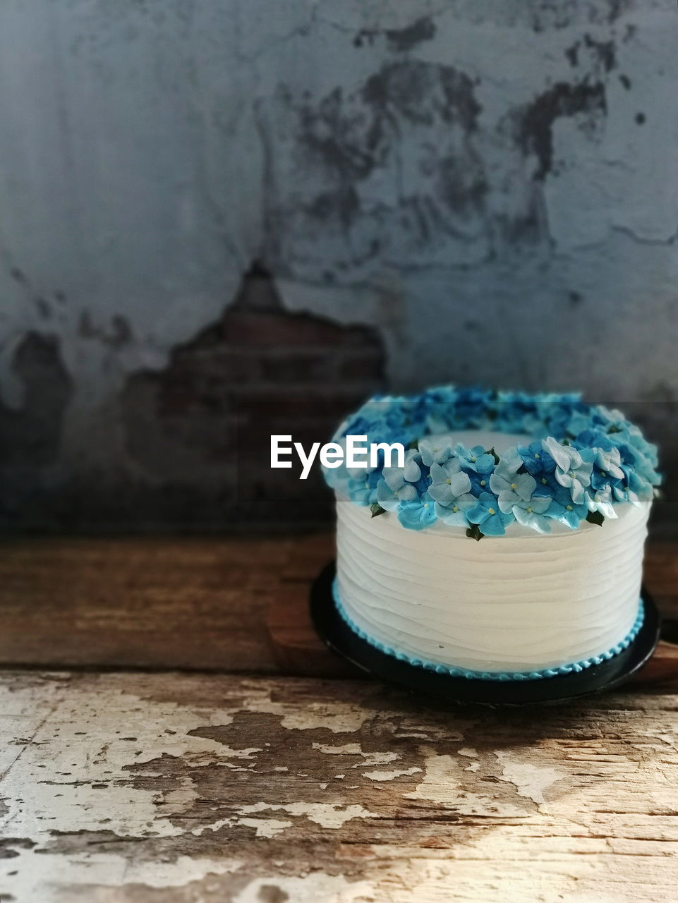 CLOSE-UP OF CAKE ON TABLE AGAINST WALL