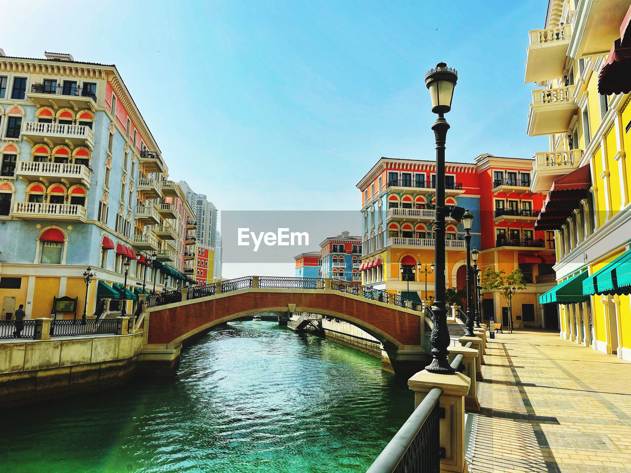 BRIDGE OVER CANAL IN CITY AGAINST CLEAR SKY