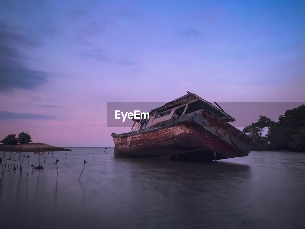 ABANDONED BOAT AT SEA AGAINST SKY