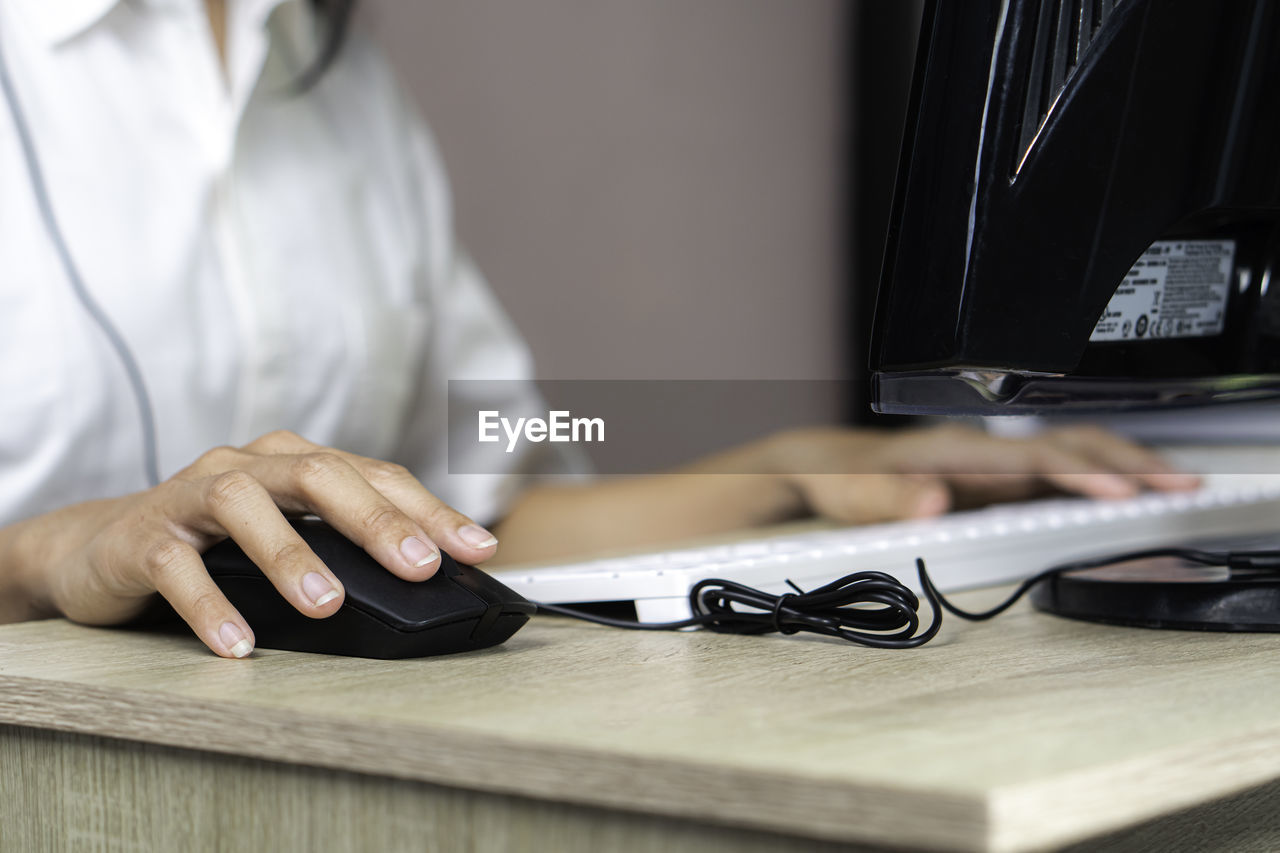 midsection of doctor using laptop on table