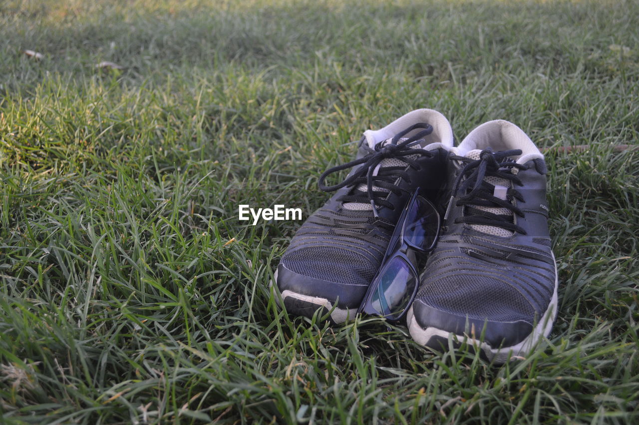 CLOSE-UP OF SHOES IN FIELD