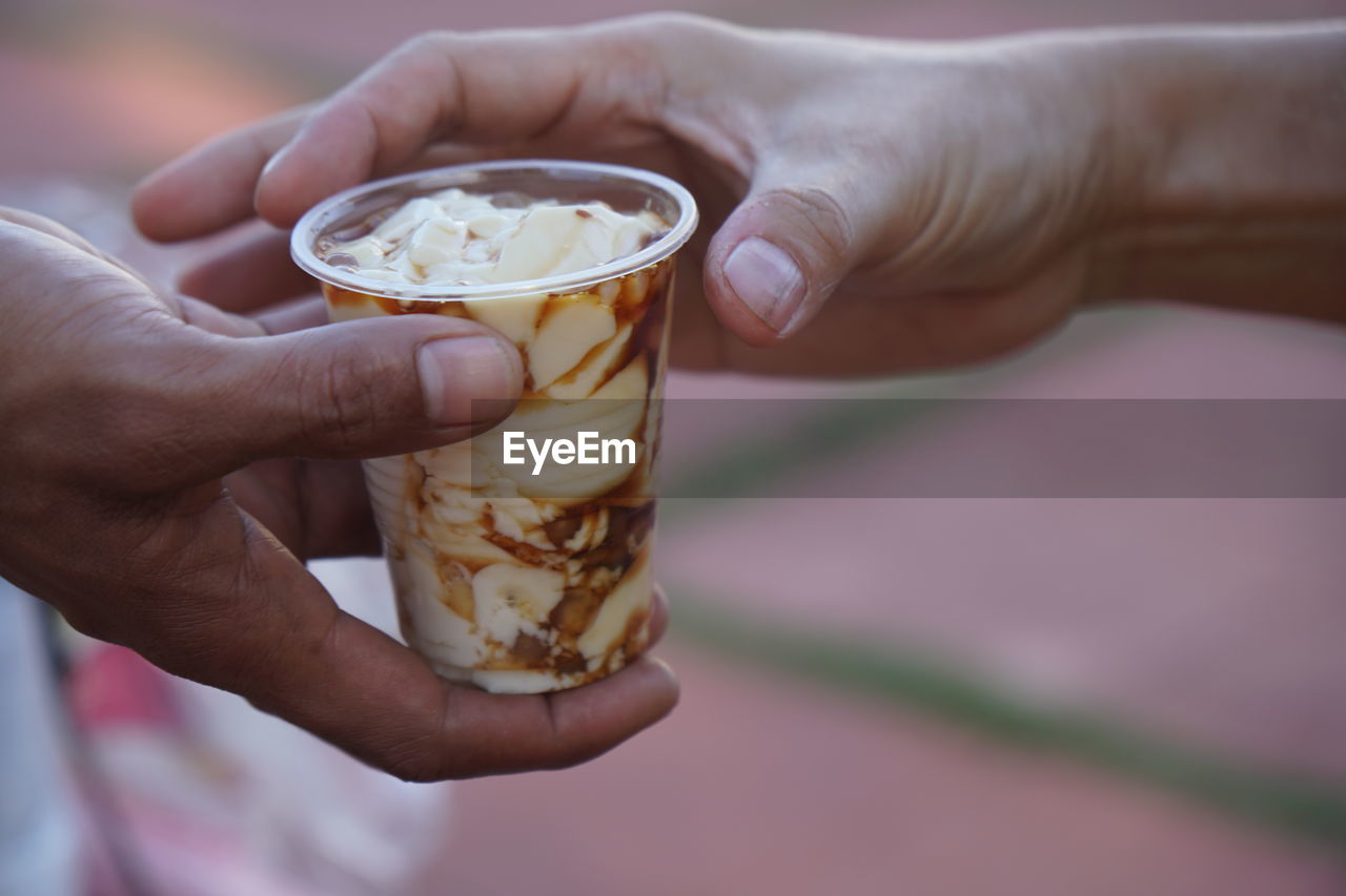 Cropped hands of people holding sweet food