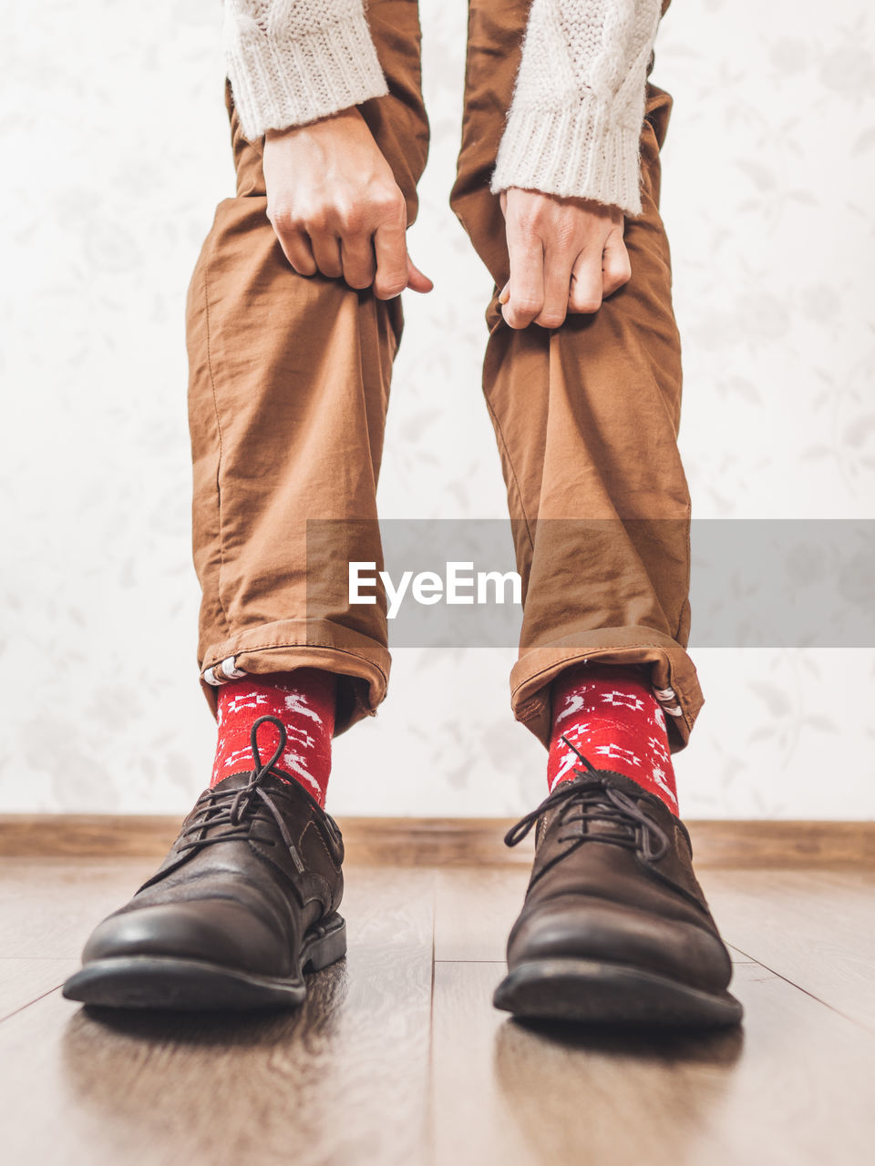 Young man shows bright red socks with reindeers.casual outfit for new year and christmas celebration