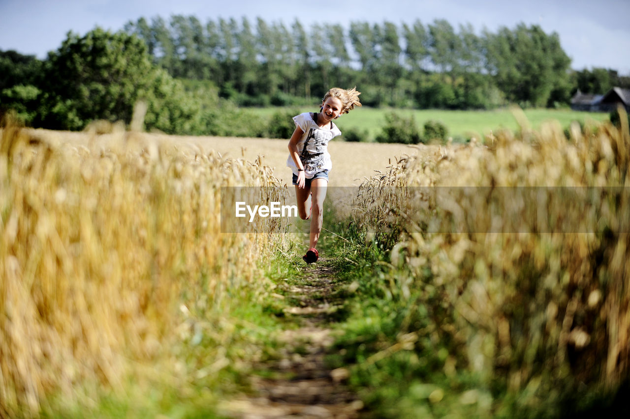 Girl running through wheat field