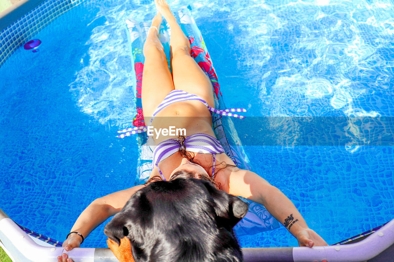 High angle view of young woman resting in swimming pool