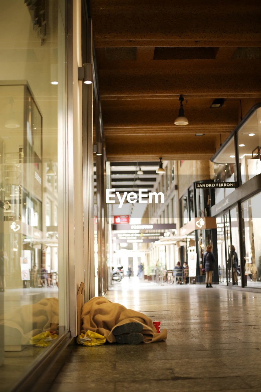 VIEW OF MAN SLEEPING IN BUILDING