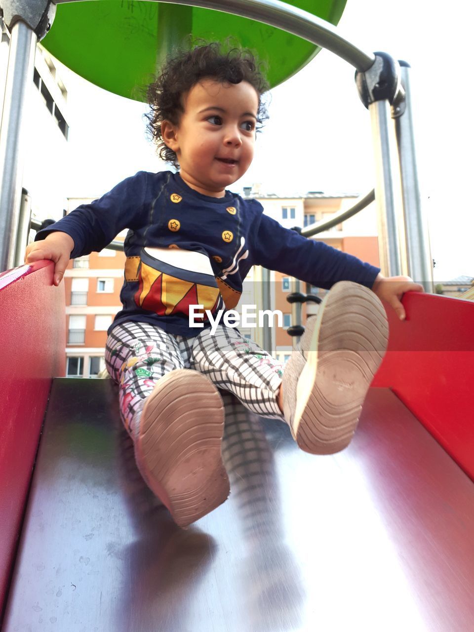 Low angle view of boy on slide