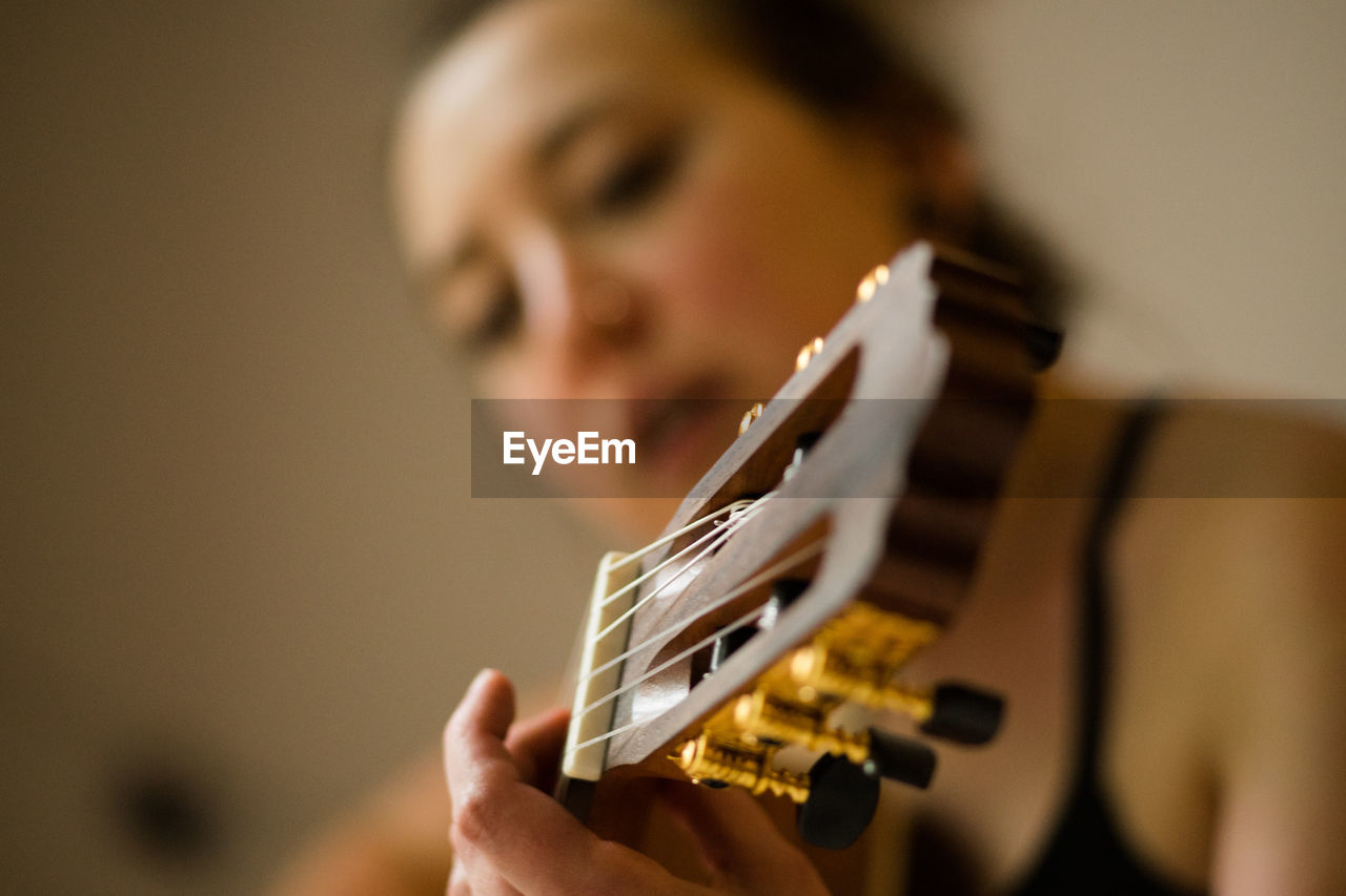 Close-up woman playing guitar