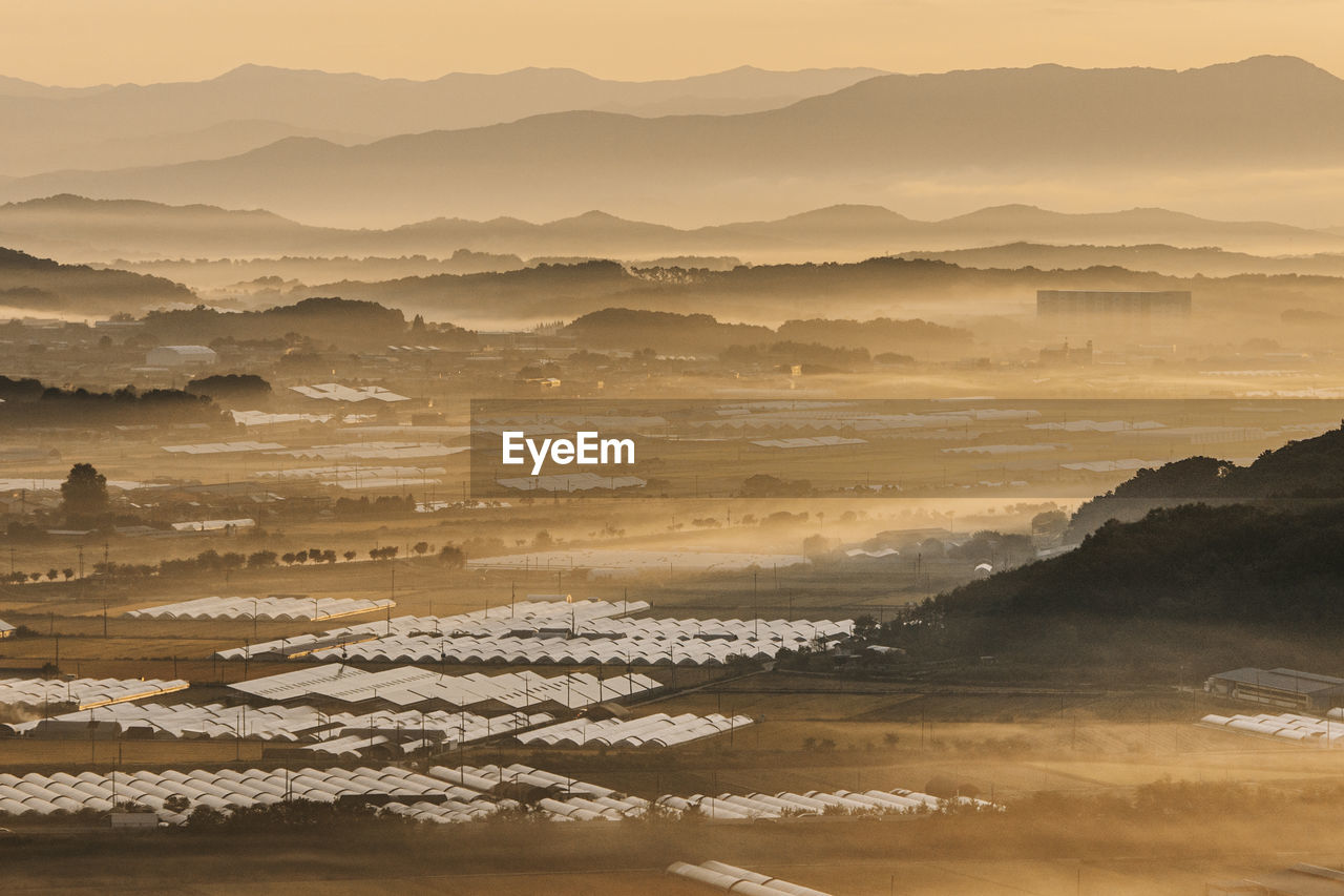 environment, landscape, land, scenics - nature, mountain, nature, beauty in nature, sky, travel, water, horizon, fog, coast, travel destinations, sunset, tranquility, sun, mountain range, sea, outdoors, no people, sunlight, architecture, tranquil scene, tourism, sand, dawn, rural scene, non-urban scene, desert, wave, building