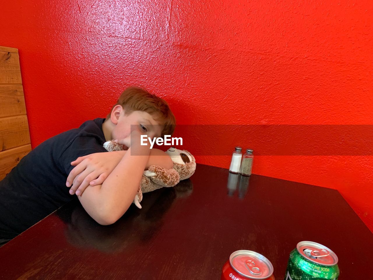 HIGH ANGLE VIEW OF BOY SITTING ON TABLE AT RED