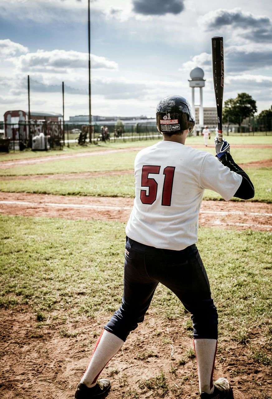 WOMAN STANDING ON FIELD AGAINST SKY