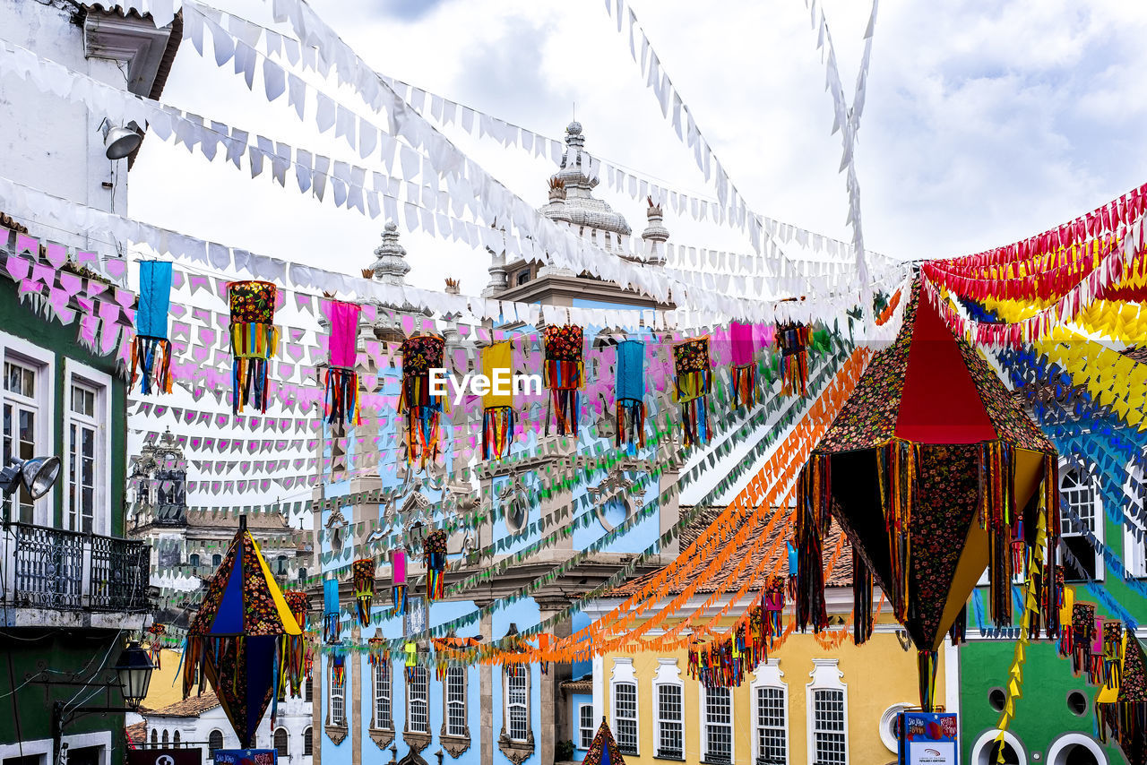 architecture, multi colored, built structure, decoration, sky, building exterior, travel destinations, hanging, tradition, city, nature, cloud, celebration, travel, outdoors, building, day, tourism, religion, no people, bunting, event, street