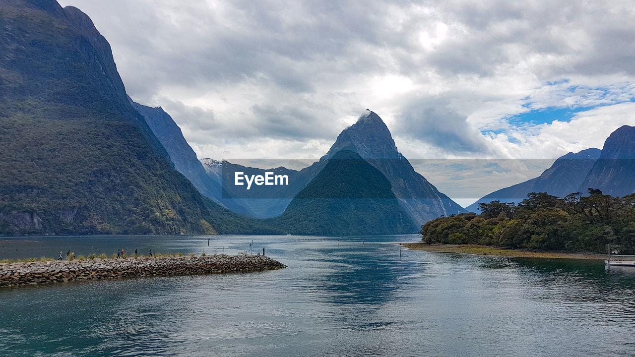 Scenic view of lake by mountains against sky