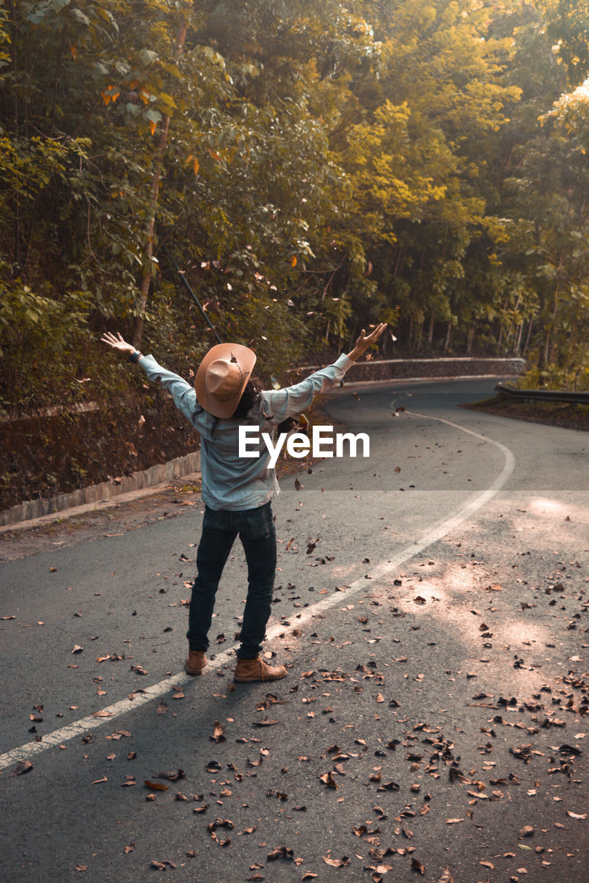 Man scattering dry leaves