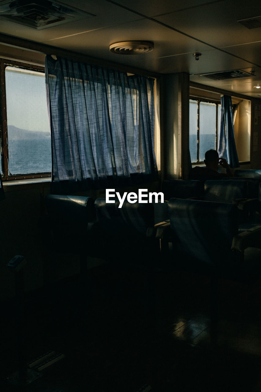 The passenger seats on the ferry boat, view through the window and curtains, passenger traveling.