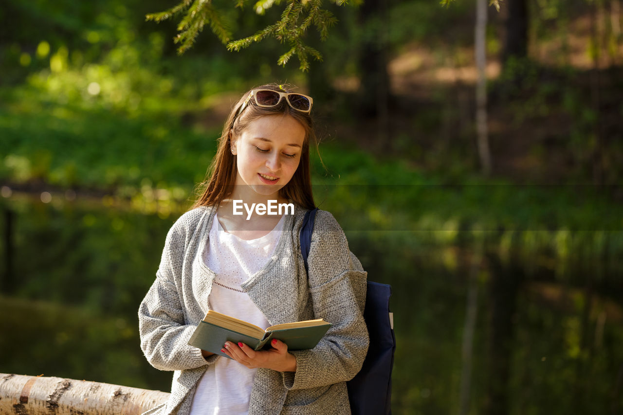 Cute girl in the park with a book in hand