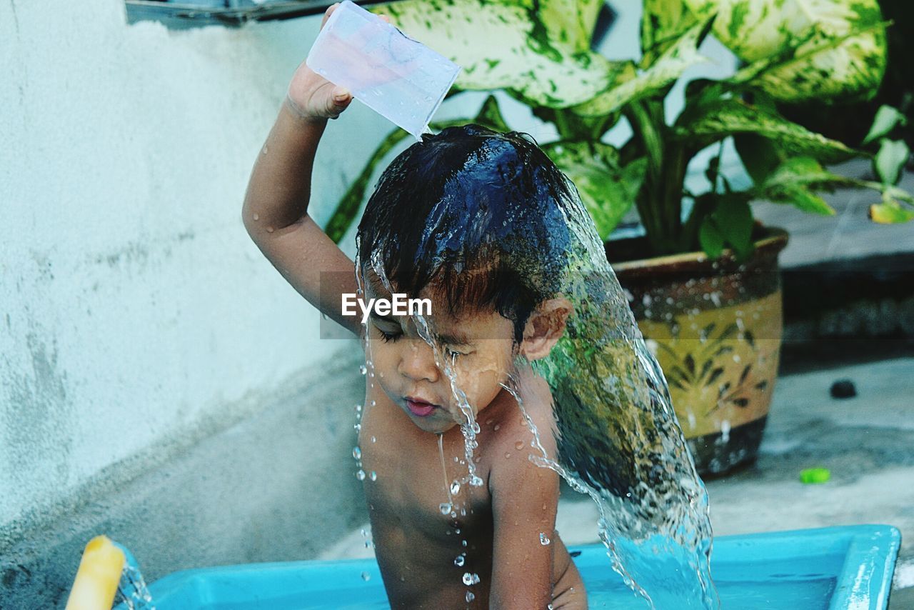 Cute boy bathing in back yard