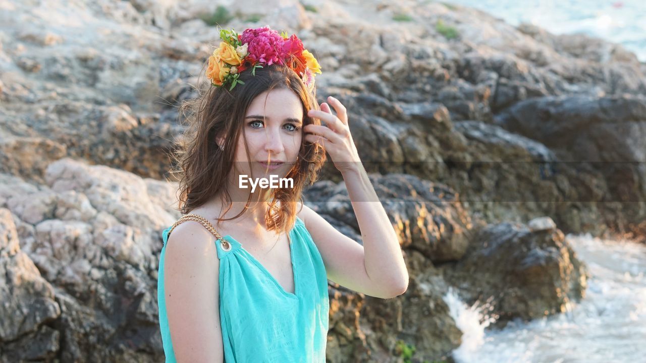 Portrait of beautiful young woman on rock