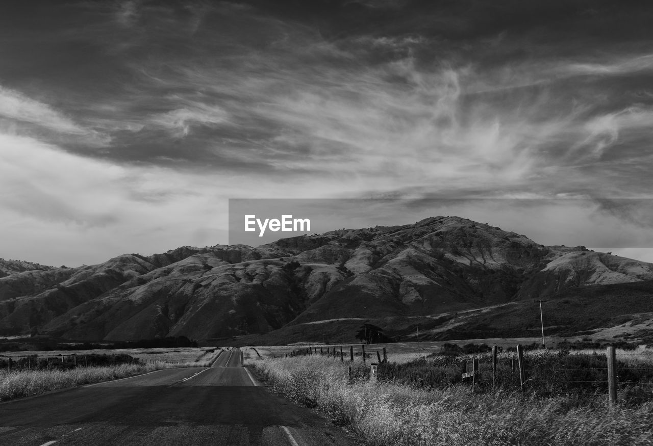 Road by mountain against sky