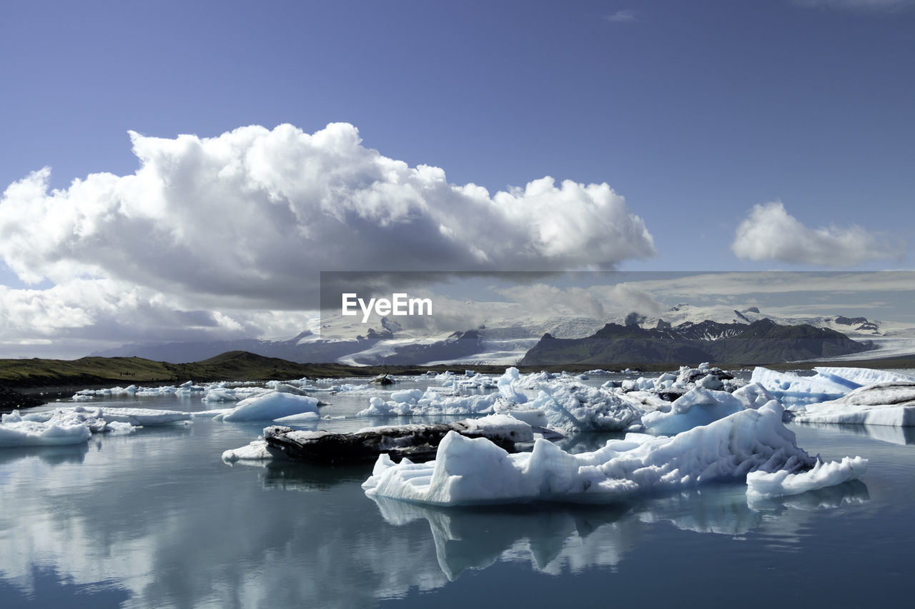 Scenic view of frozen lake against cloudy sky during winter