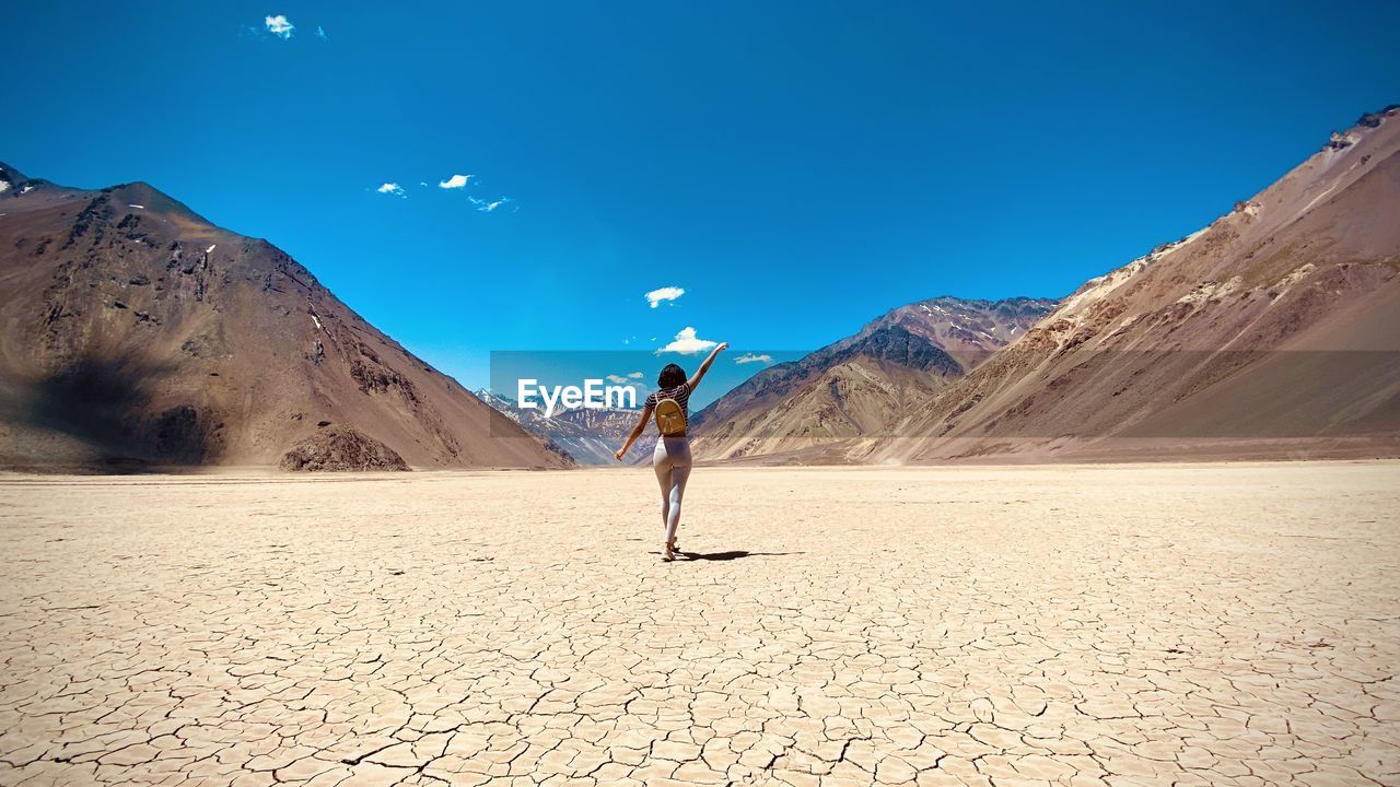 Full length of woman on arid landscape against sky