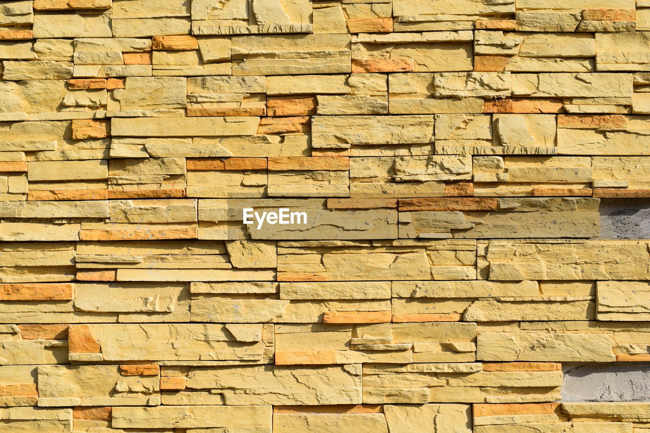FULL FRAME SHOT OF STONE WALL WITH WOOD