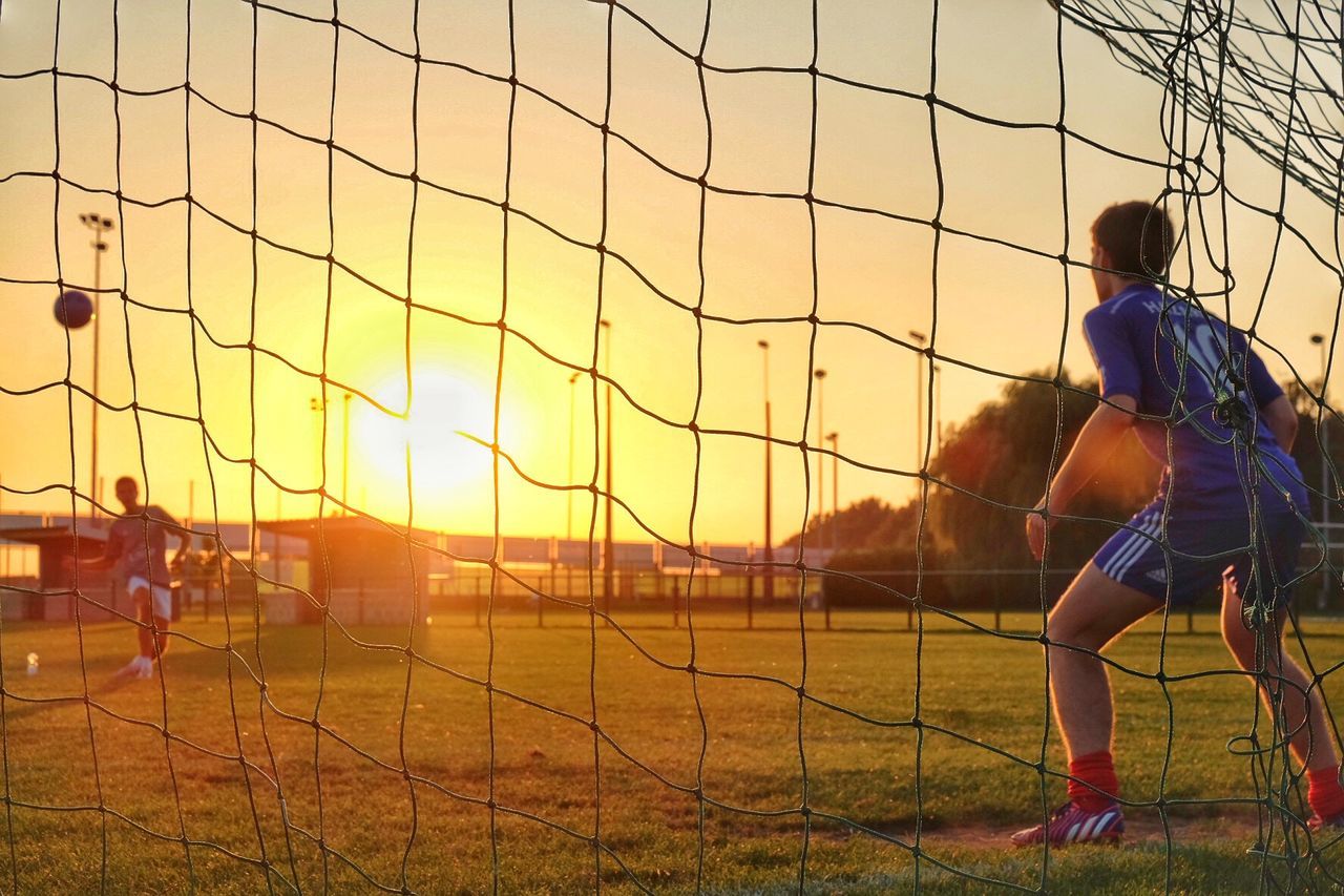 YOUNG WOMAN STANDING AT SUNSET