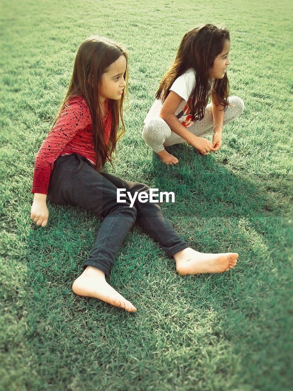 YOUNG WOMAN SITTING IN GRASS