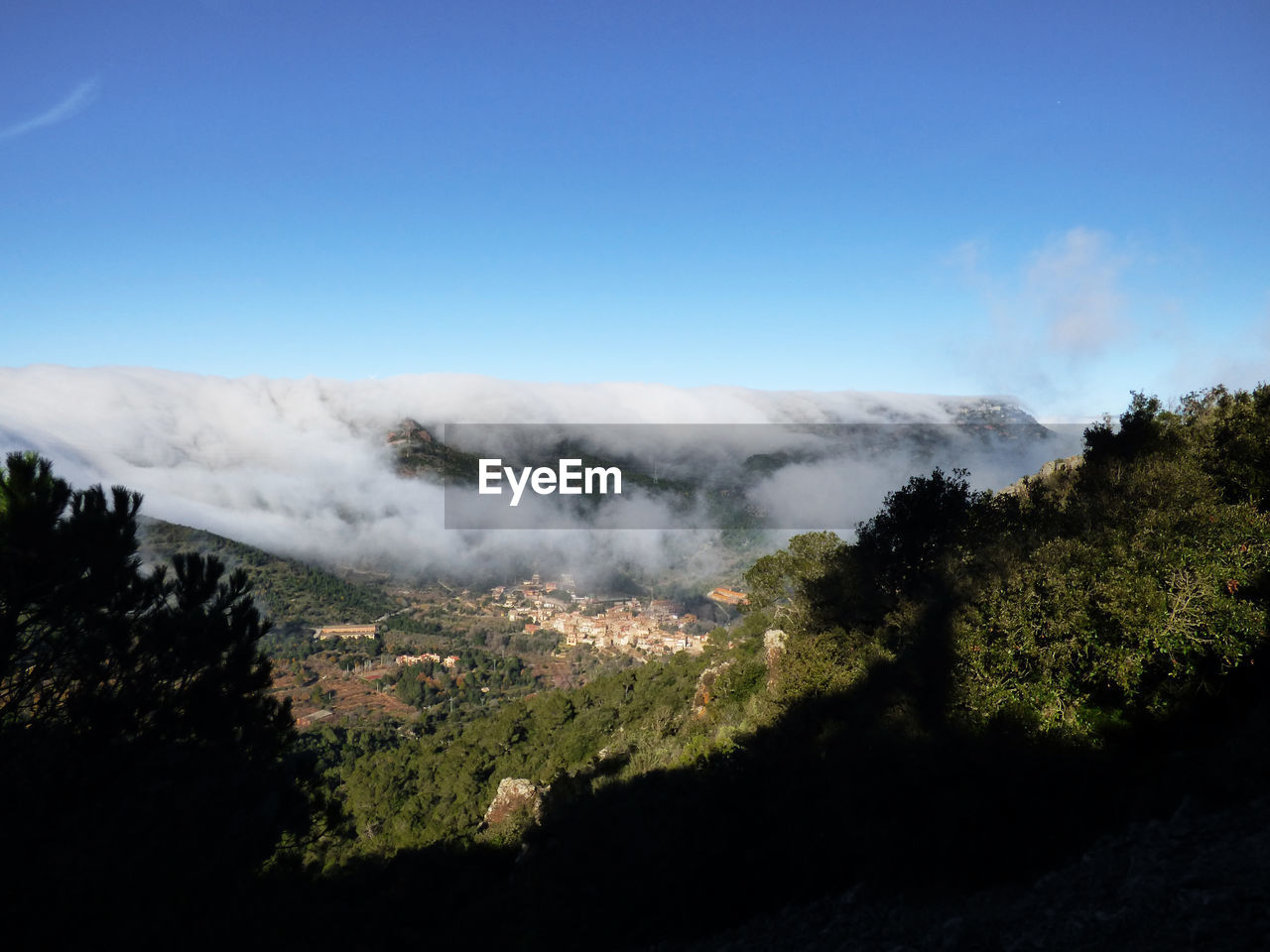 Smoke emitting from mountain against clear blue sky