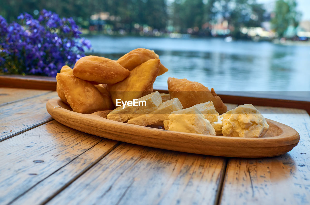 Fluffy fritters and white domestic cheese and cream served served outdoor