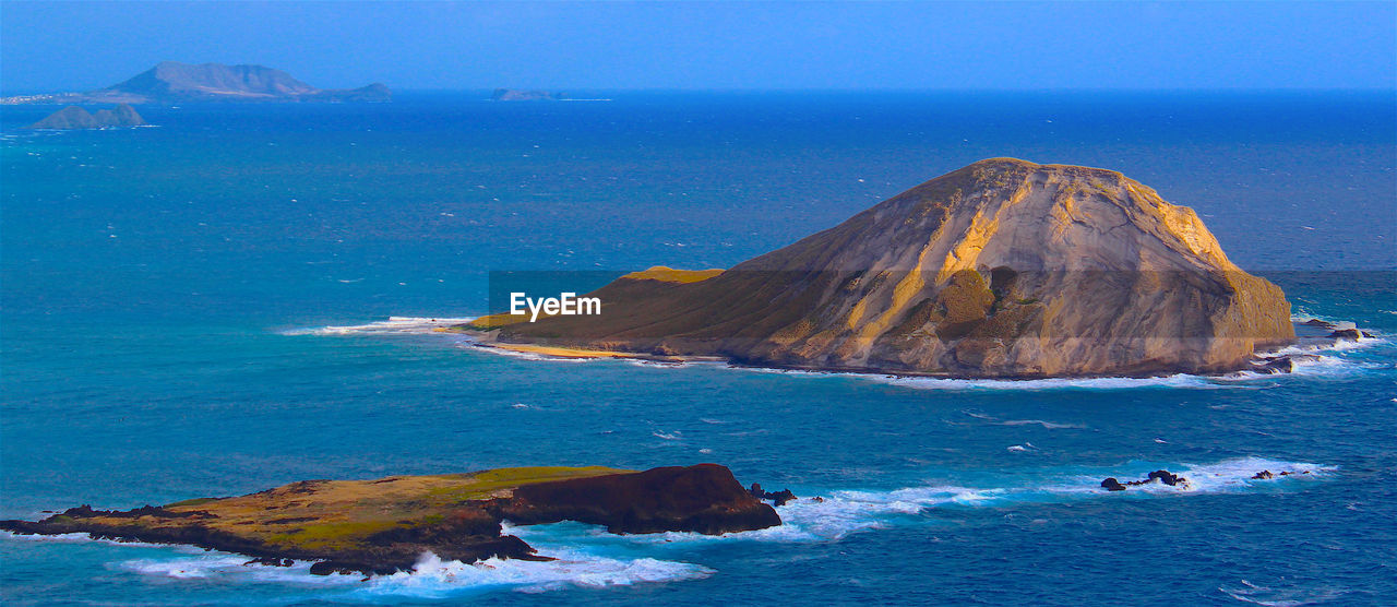Panoramic shot of headland in calm blue sea