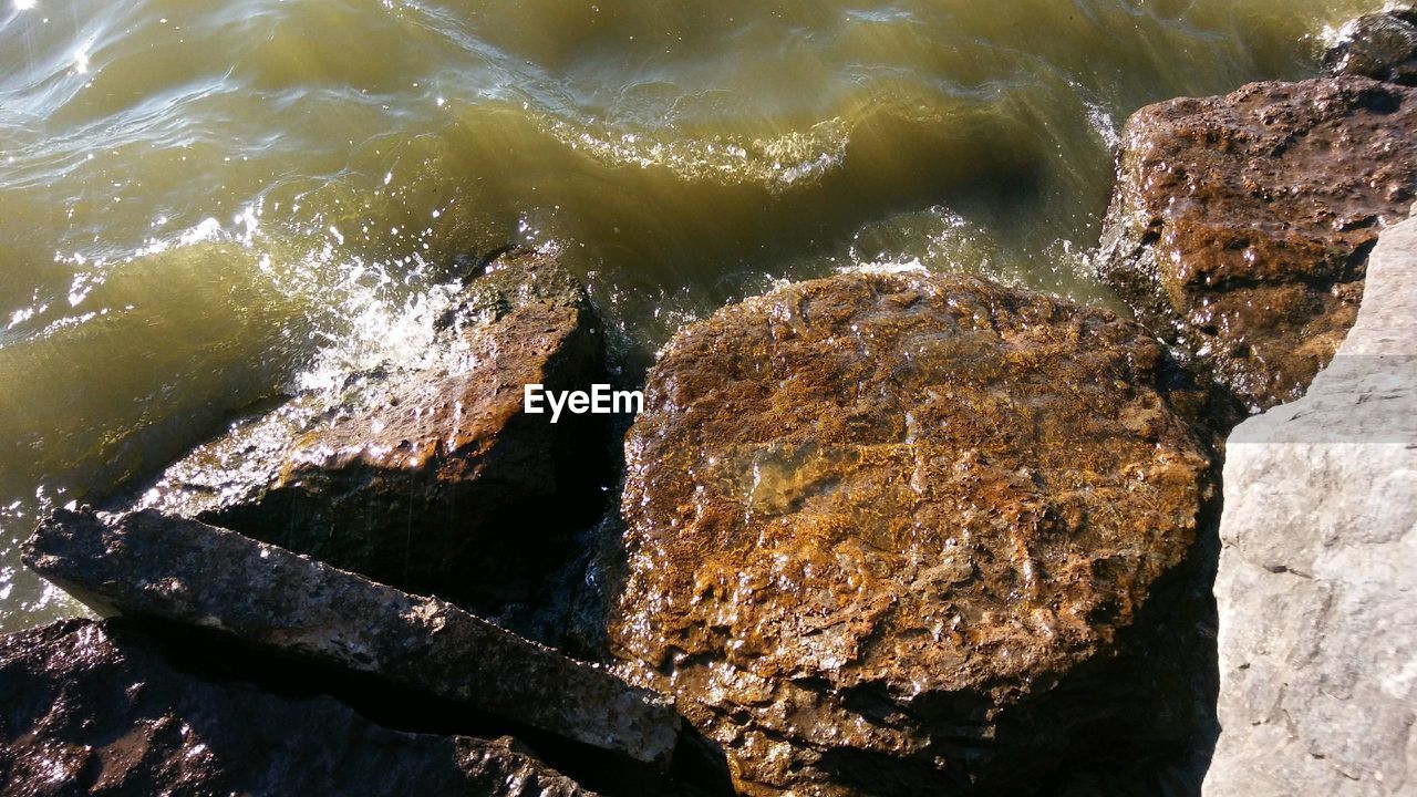 HIGH ANGLE VIEW OF ROCK BY SEA