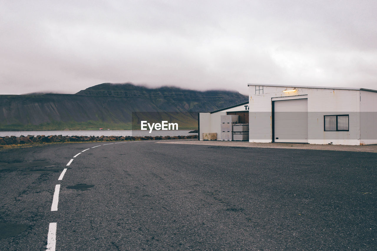 Cabin by road against mountains