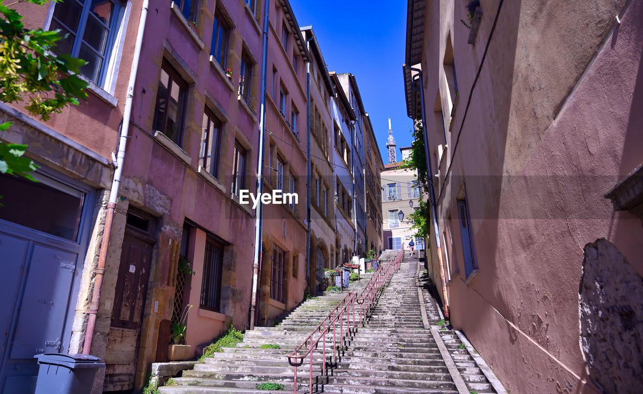 NARROW FOOTPATH AMIDST BUILDINGS IN CITY