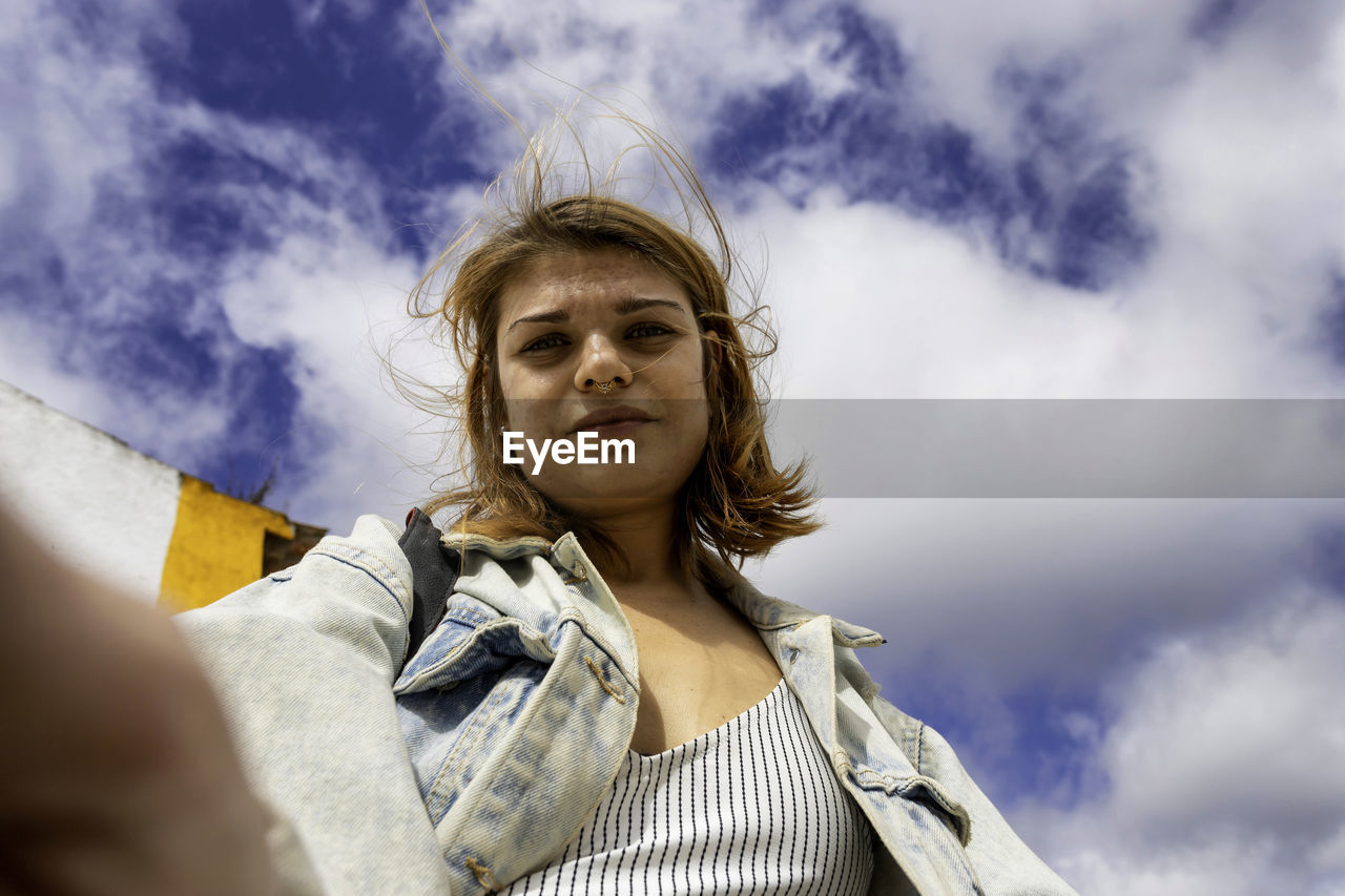 Portrait of woman doing selfie against sky