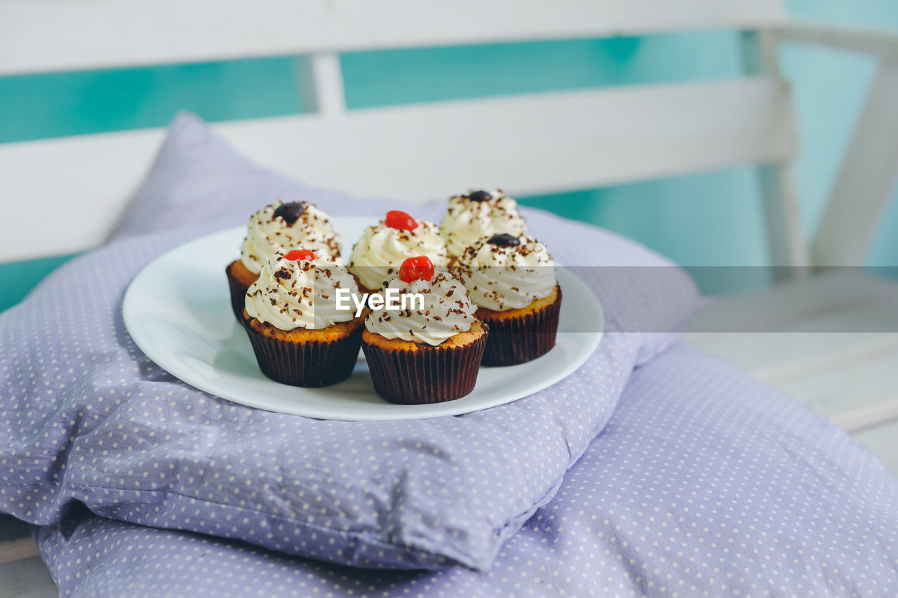 Close-up of cupcakes in plate on pillow