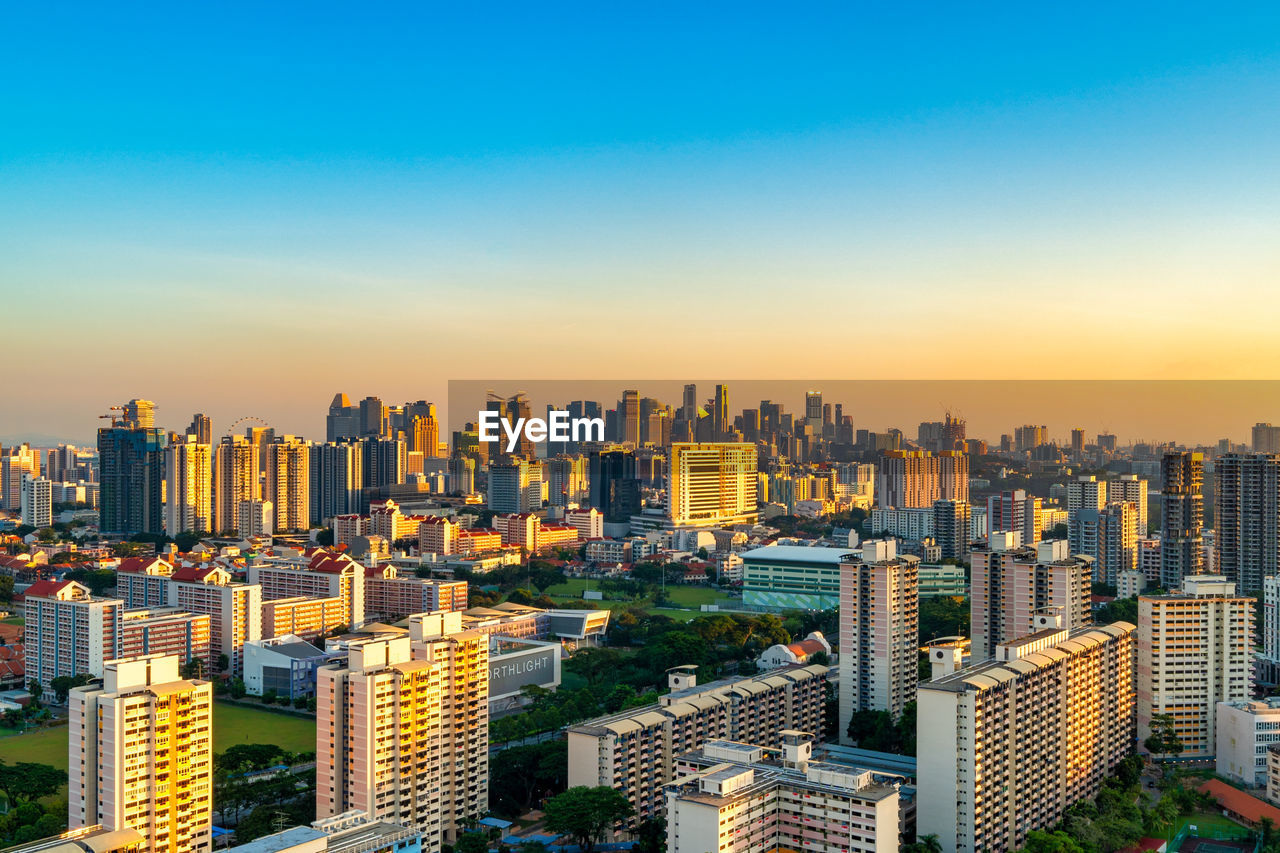 Aerial view of buildings in city against clear sky