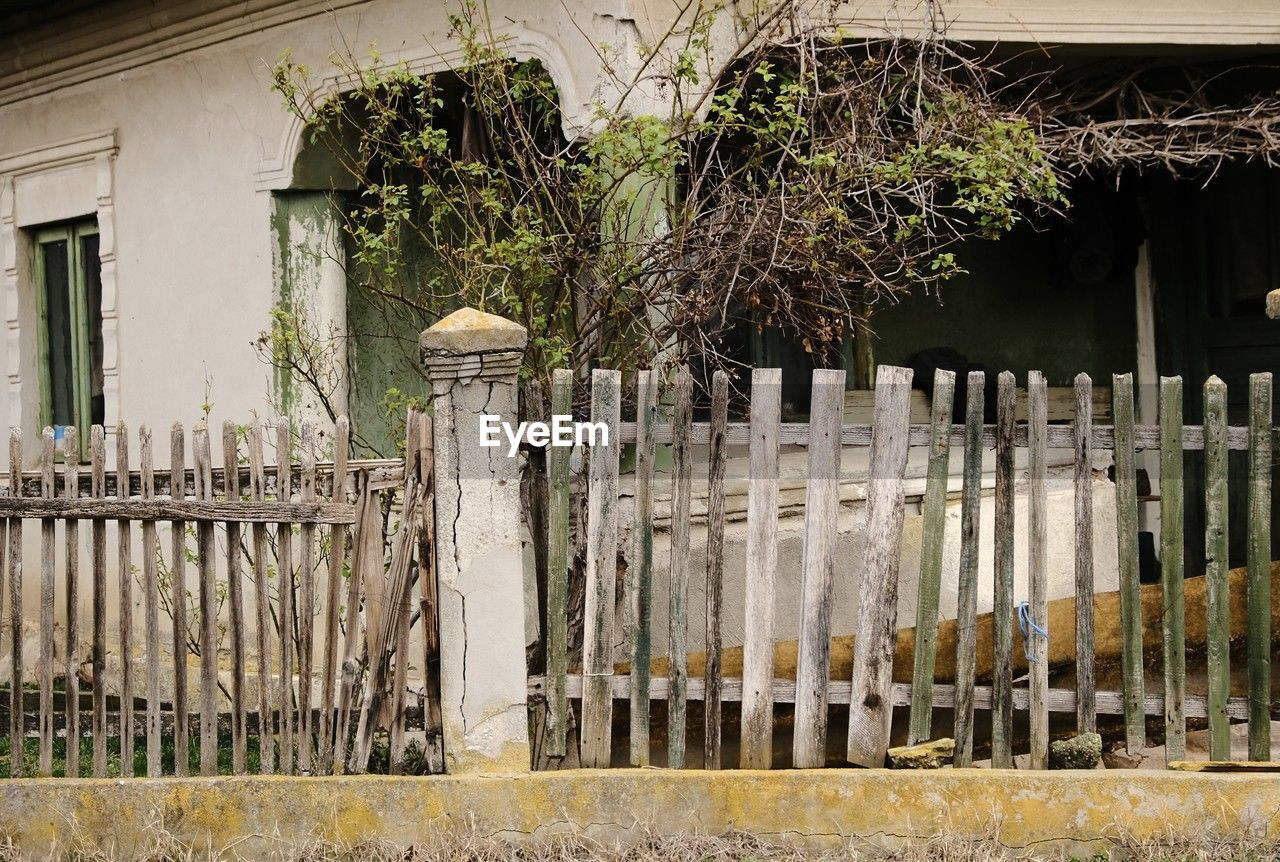 picket fence, architecture, fence, built structure, no people, plant, building exterior, building, home fencing, house, gate, security, protection, nature, wood, day, wall, outdoors, outdoor structure, tree, residential district, iron, estate, history, entrance